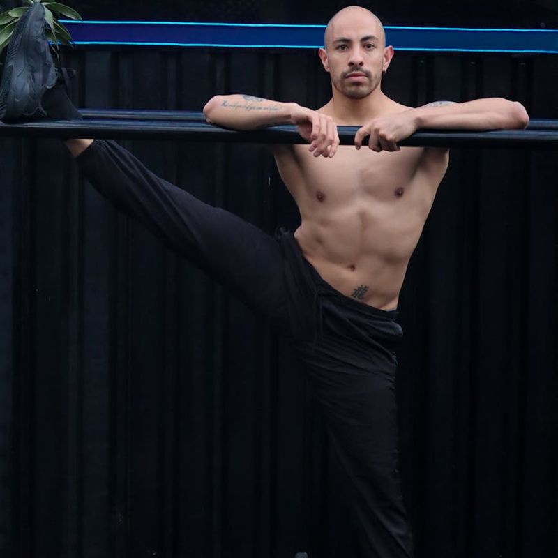Man holding a difficult static pose, demonstrating muscle control and balance.